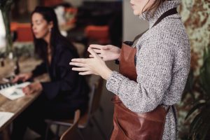 florentine leather: female owner gesturing while standing at workshop